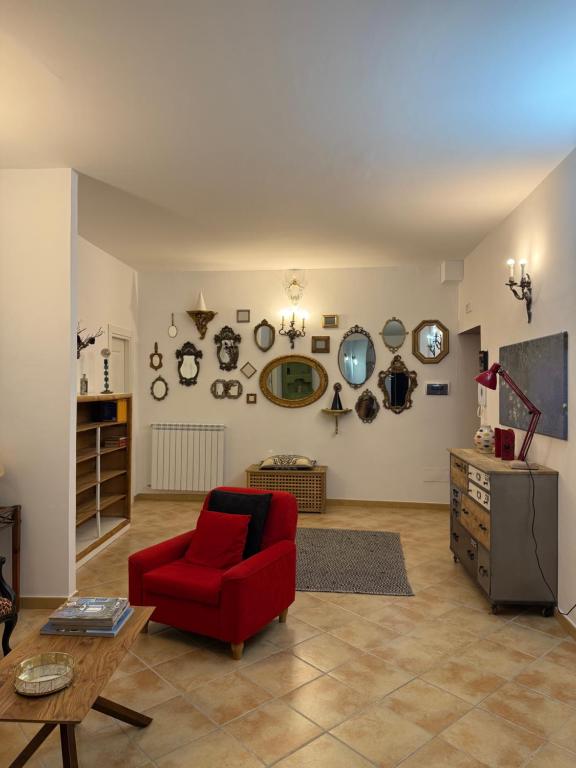 a living room with a red chair and a table at Affittacamere Le Canossiane in Piedimonte dʼAlife