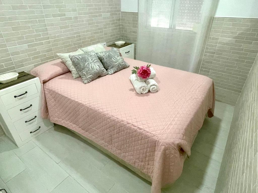 a pink bed with a stuffed animal on top of it at AITA CASA BARBATE in Barbate