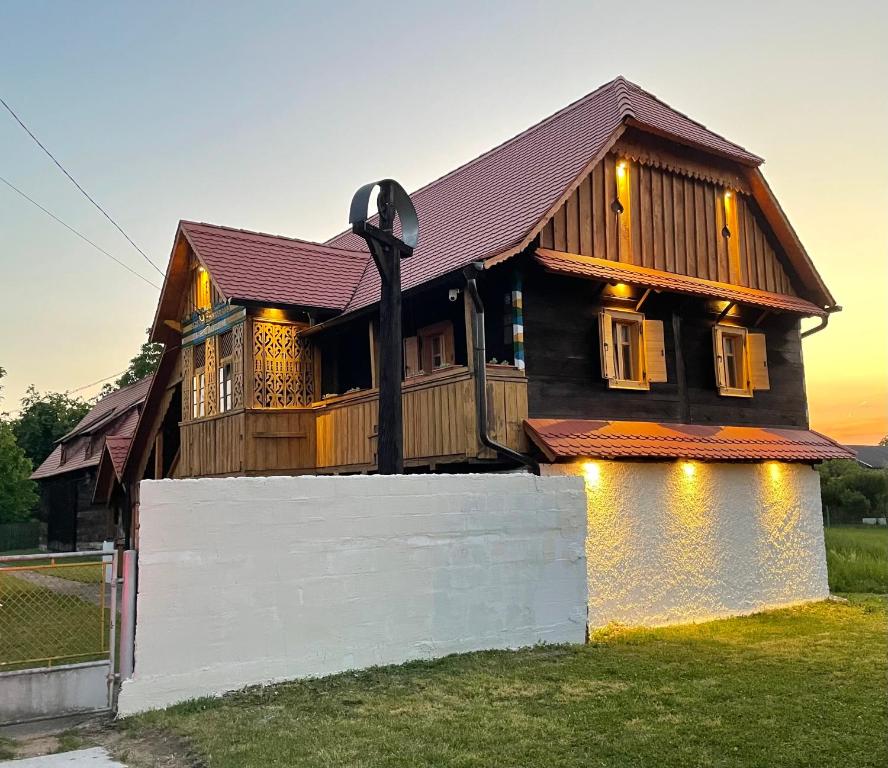 a large wooden house with a white fence at Čardak Mraclin in Mraclin