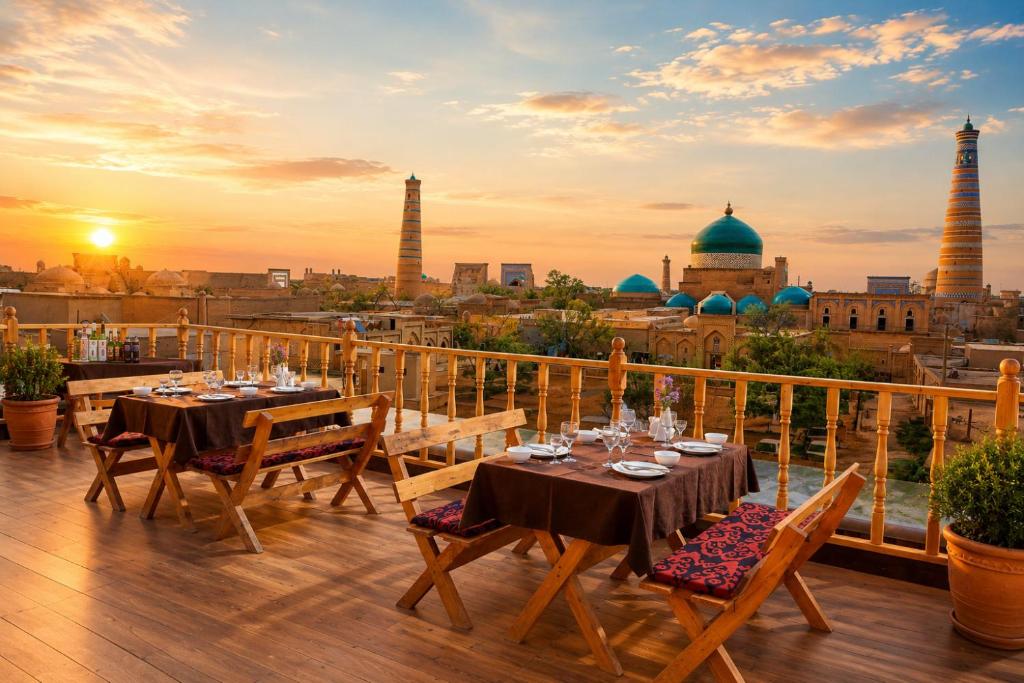 a balcony with tables and chairs with a view of a city at Arkanchi Boutique Hotel in Khiva