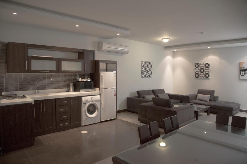 a kitchen and living room with a couch and a microwave at Rafa Homes Al Izdihar 2 in Riyadh