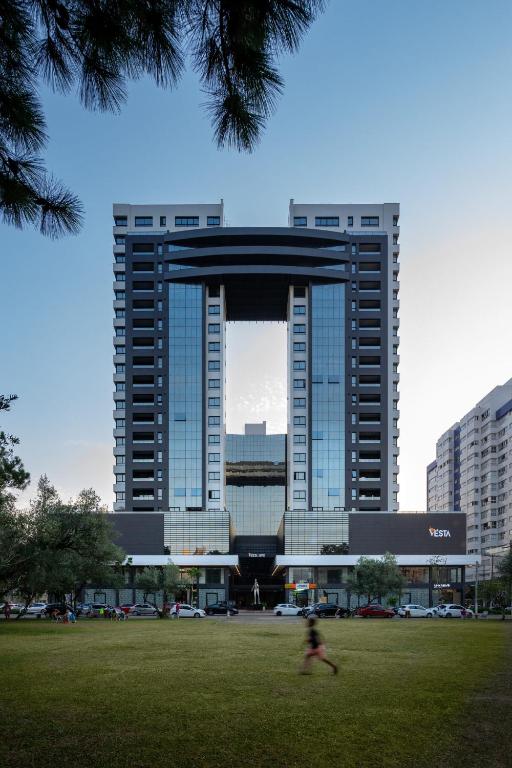 a person running in front of a large building at Vesta - melhor localização Torres in Torres