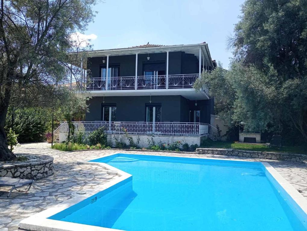 a villa with a swimming pool in front of a house at Iris Villa in Apolpaina