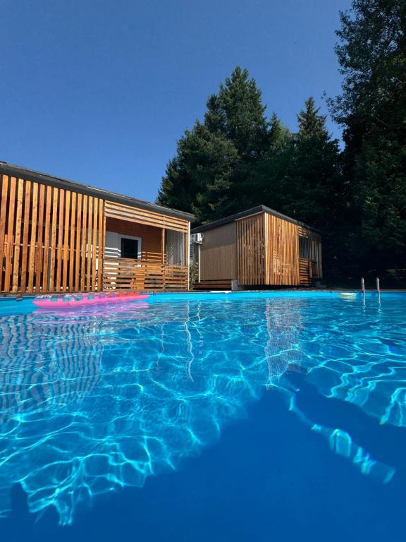 a large swimming pool in front of a house at Bungalows Sonnenblume am Klopeiner See in Sankt Kanzian