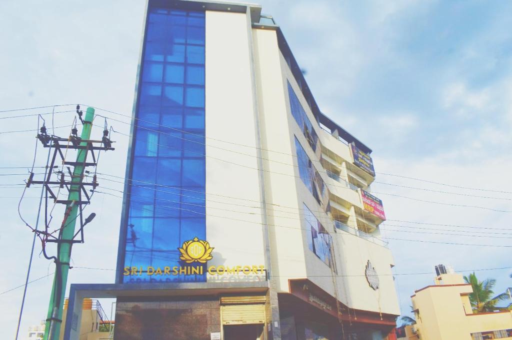 a building with a clock on the side of it at Sri Darshini Comfort Hinkal Mysore in Vānivilāsa Puram