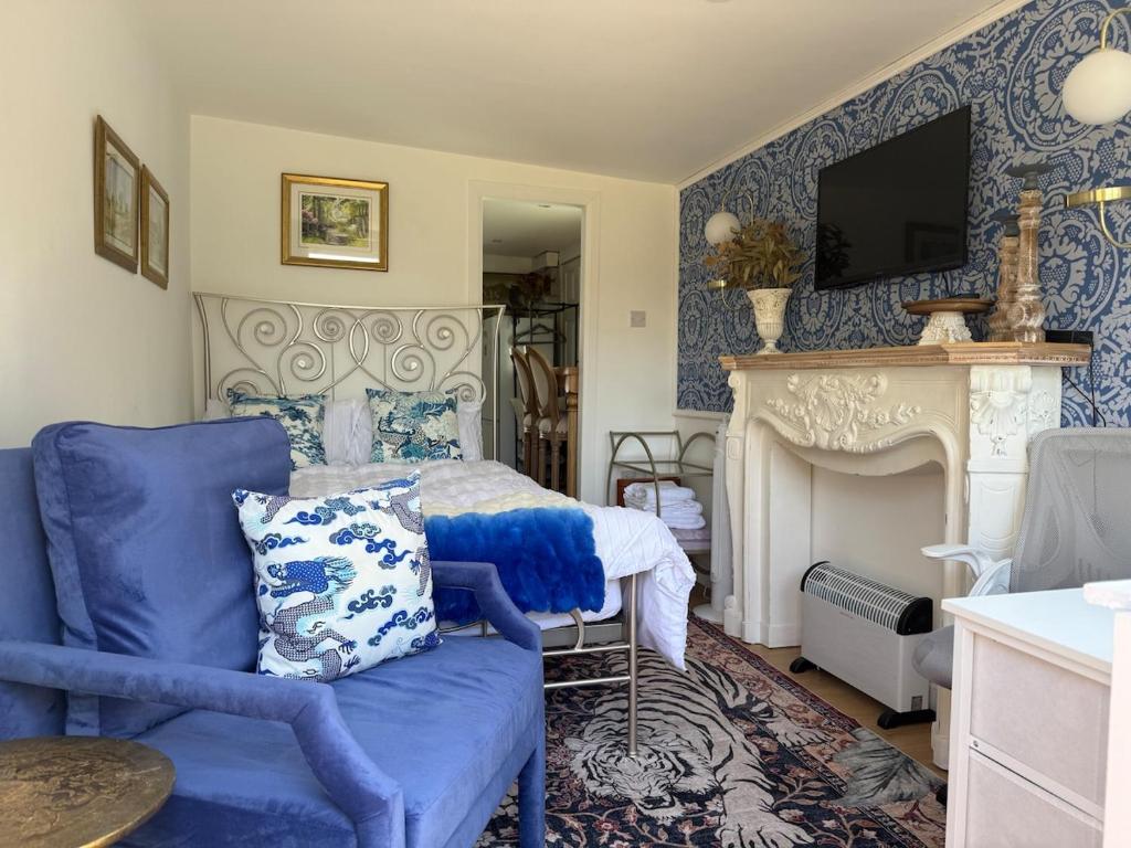 a bedroom with a bed and a chair and a fireplace at Lakeside Haven in The Hyde