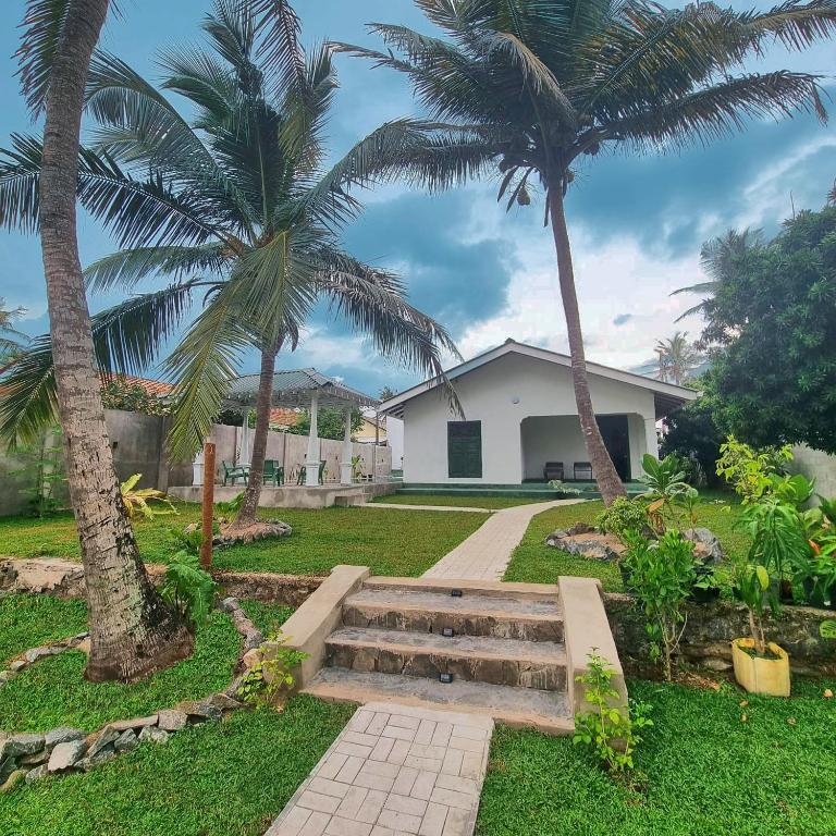 a house with two palm trees and a staircase at Shells By D in Negombo