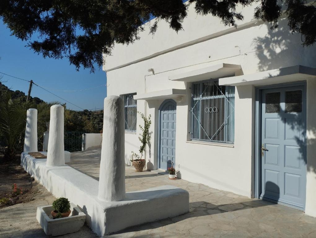 a white house with a door and a porch at White Cat in Vromolithos