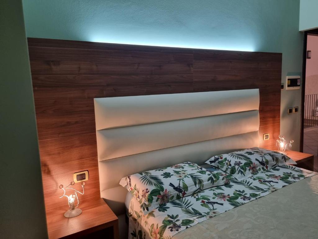 a bedroom with a bed with a large wooden headboard at Pensione degli Ulivi in Porto SantʼElpidio