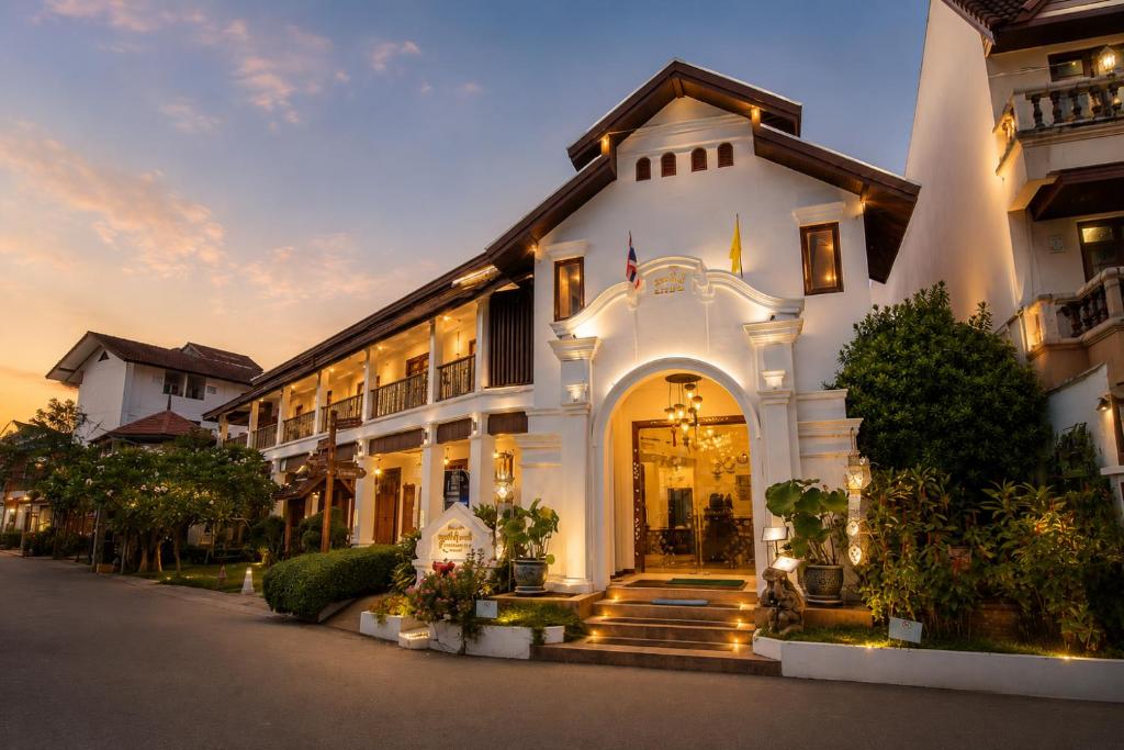 a large white building with a front door at Kodchasri Thani Heritage Collections in Chiang Mai
