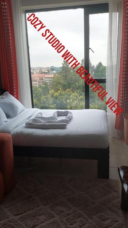 a bed in a room with a large window at Reinastays in Kiambu