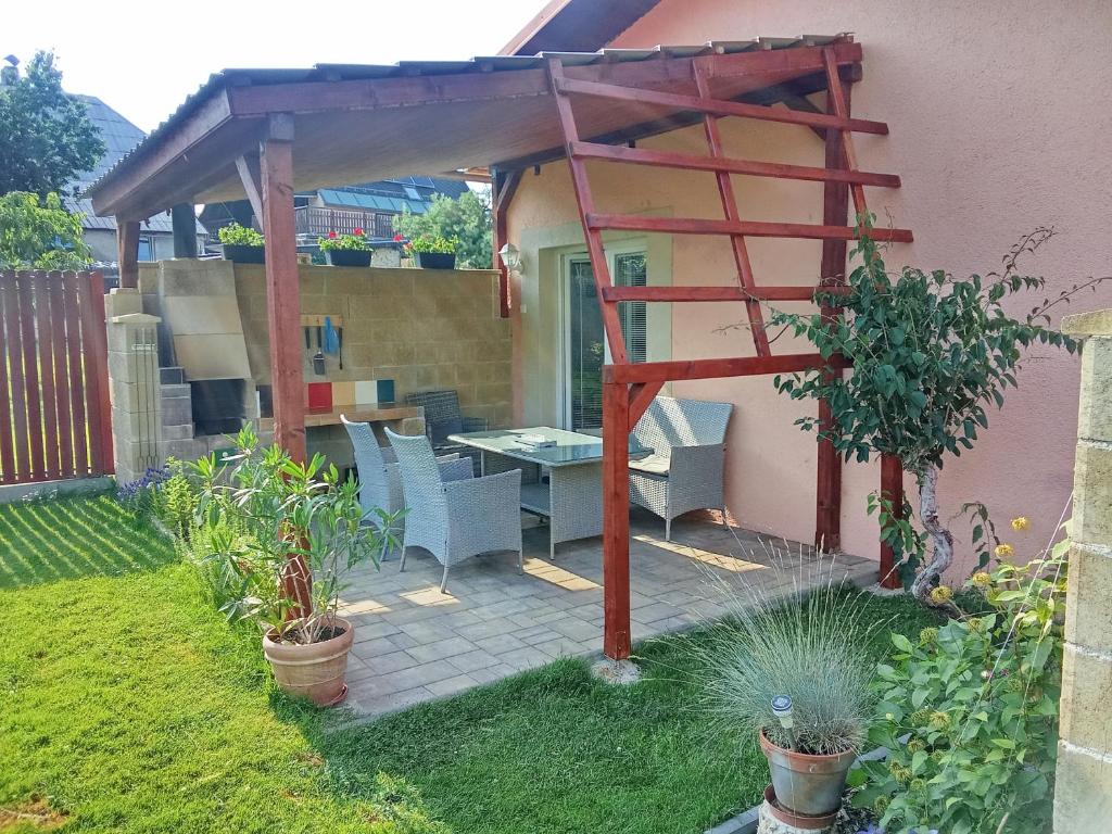 a patio with a table and chairs under a pergola at Bungalov Mikulášovice in Mikulášovice
