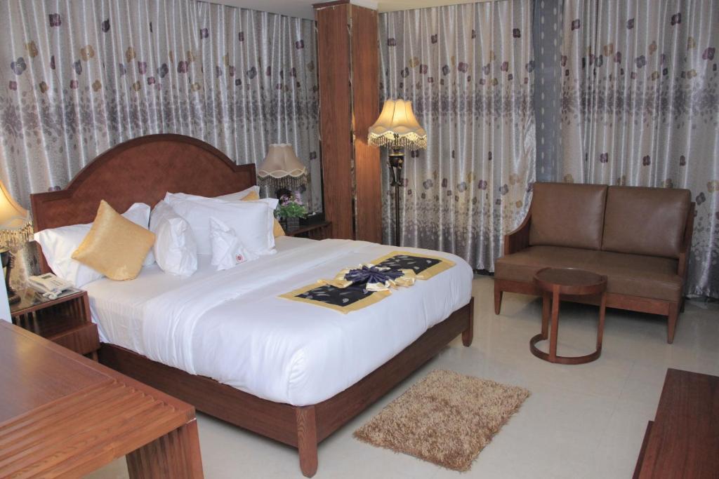 Habitación de hotel con cama y silla en Zimbo Golden Hotel en Dar es Salaam
