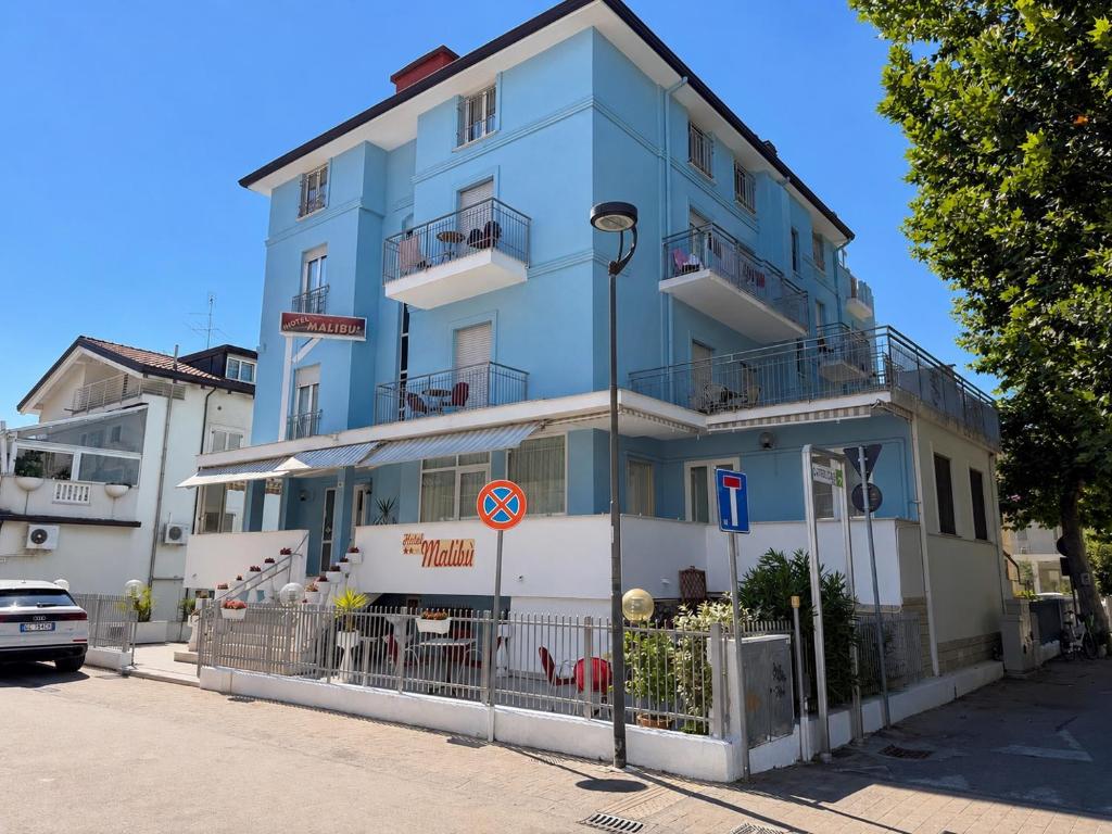 a blue building on the side of a street at Hotel Malibù in Rimini