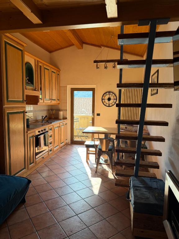a kitchen with a spiral staircase leading to a table at Cèsa MeSa in Canazei
