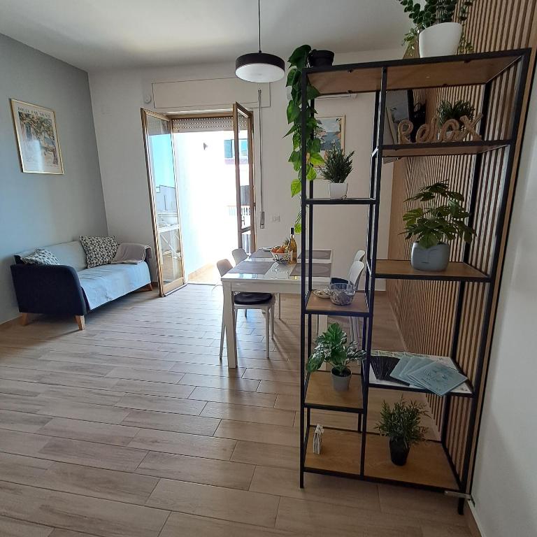 a living room with a table and a shelf with plants at Bella Italia in Marina di Strongoli