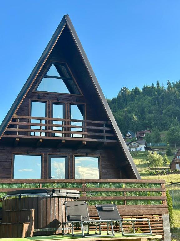 a log cabin with two chairs and a table at Rivera Cabin in Colibiţa