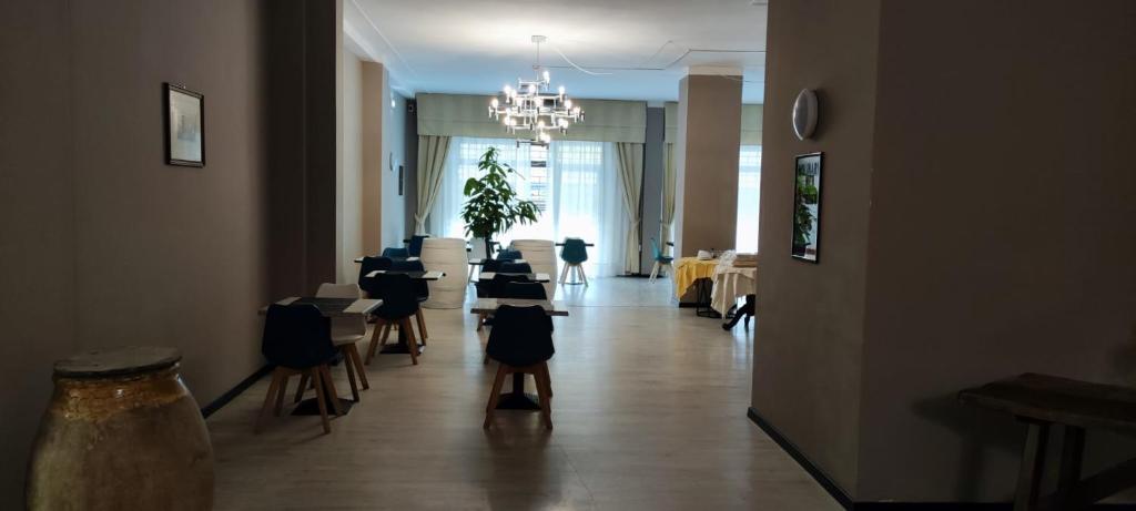 a dining room with tables and chairs and a chandelier at Hotel Europa in Arma di Taggia