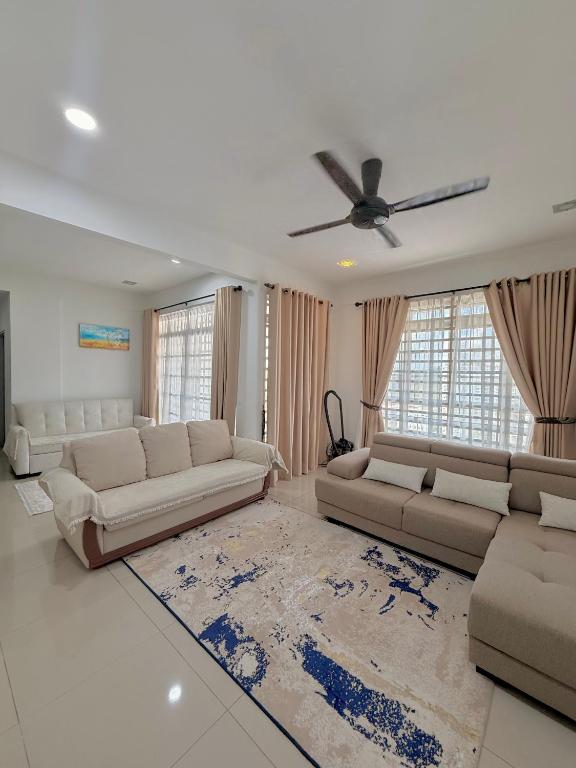 a living room with two couches and a ceiling fan at Singgah homestay saujana aster in Putrajaya