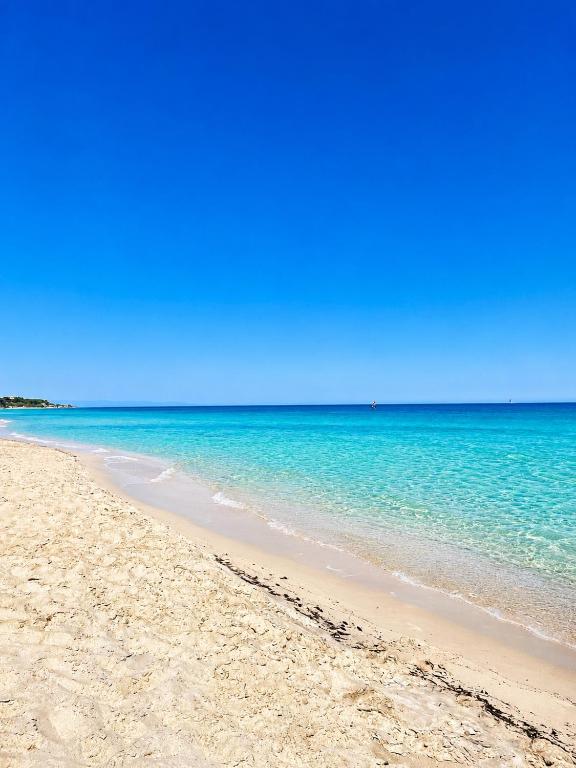 a sandy beach with the ocean in the background at VR-Room in Forte Village