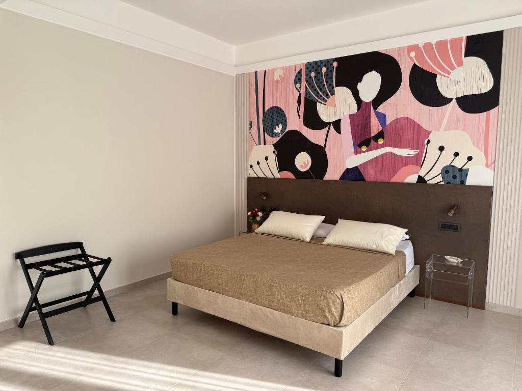 a bedroom with a bed with a painting on the wall at BellDuomo Suite Messina in Messina