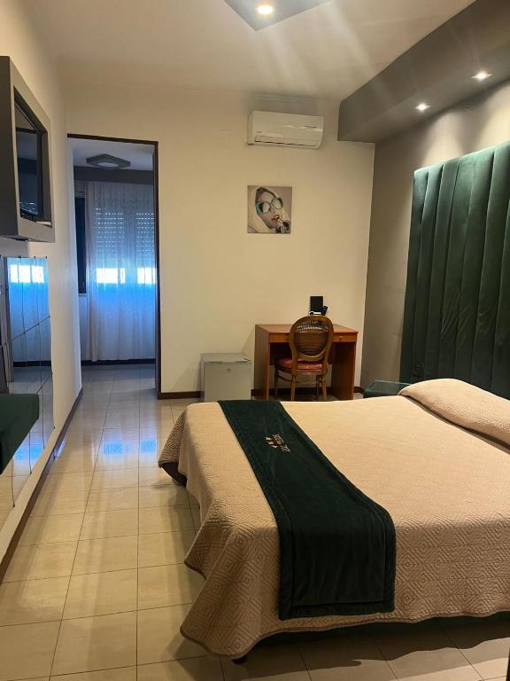 a bedroom with a bed and a table and a desk at Hotel Joy in Castel Volturno