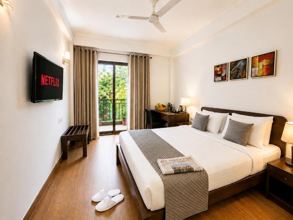 a hotel room with a bed and a tv at EMBLEM Hotel - Arjun Marg, Golf Course Road, Gurgaon in Gurgaon
