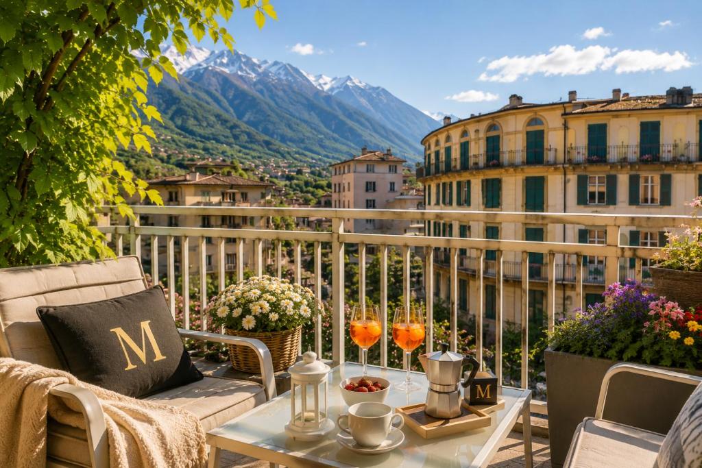 a balcony with a table and two glasses on it at MARY HOUSE Central Station Large Apartment in Sondrio