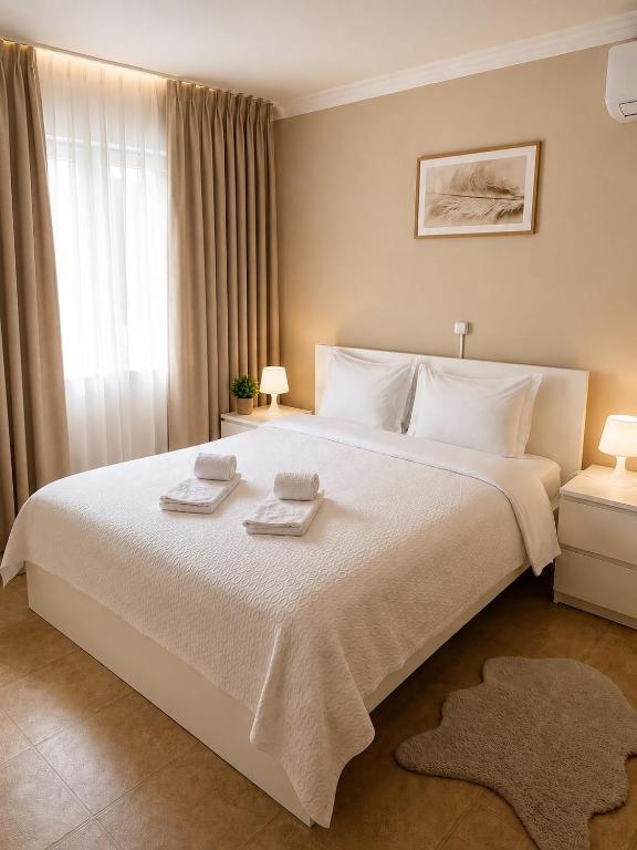 a bedroom with a large white bed with towels on it at Residencial Princesa do Ave in Vila do Conde