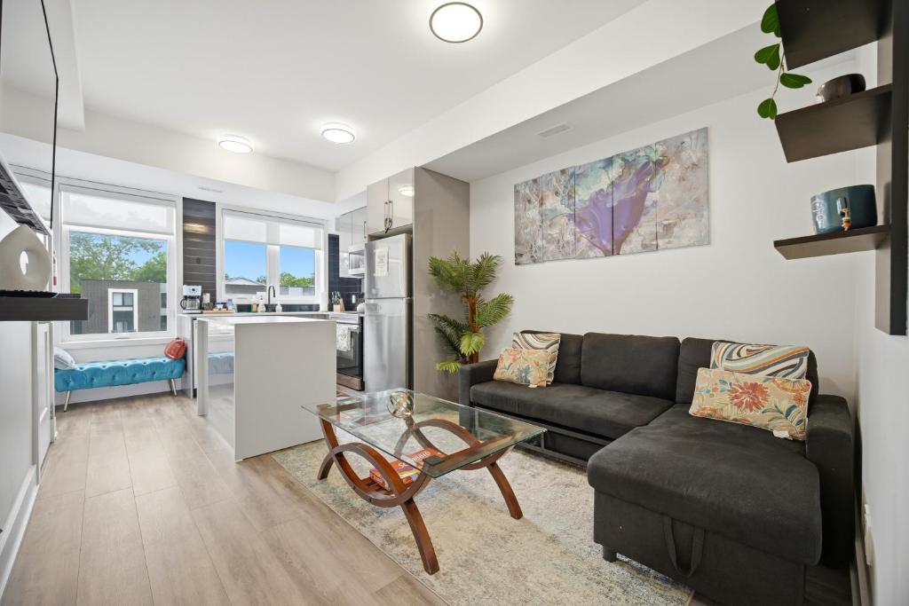 a living room with a couch and a table at Exquisite, Bright & Modern Condo - Free Parking in Niagara Falls