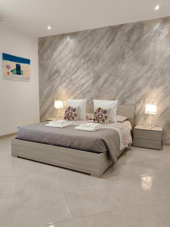 a bedroom with a large bed with two lamps at Casa Low Cost in Tuglie