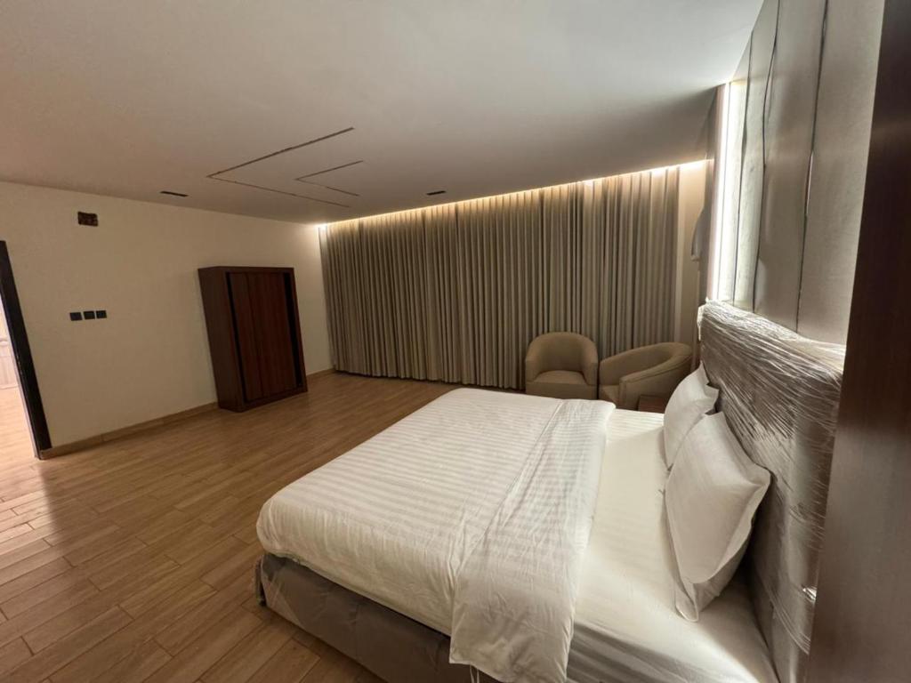 a hotel room with a bed and a window at ارام للشقق المخدومة in Taif