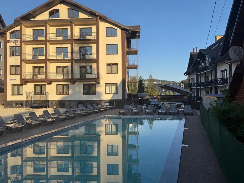 a hotel with a swimming pool in front of a building at Madison in Bukovel