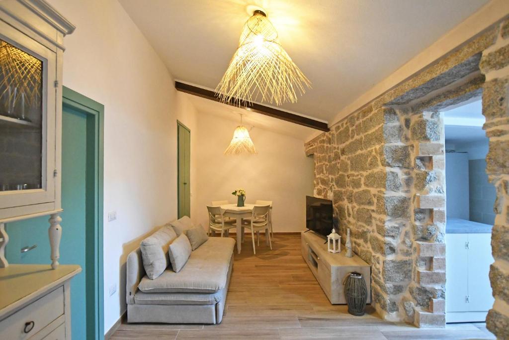a living room with a couch and a stone wall at Stazzo Rosalba in Arzachena