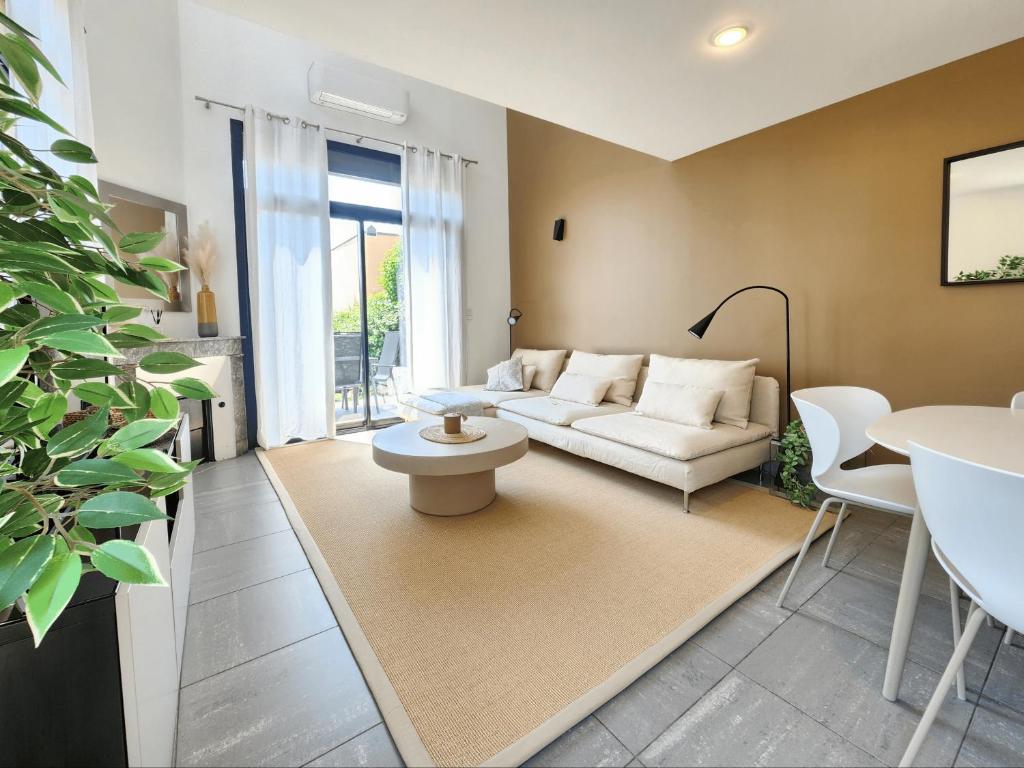 a living room with a couch and a table at La villa d'Alix avec jardin et parking in Bègles