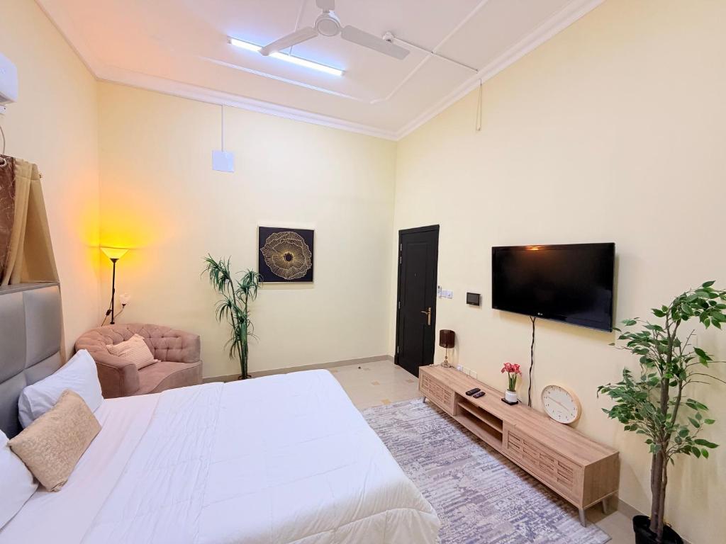 a bedroom with a large bed and a flat screen tv at Modern Studios Apartments in Juffair and Exhibition in Manama