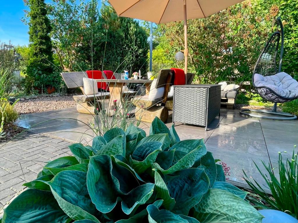 eine Terrasse mit Sonnenschirm, Tisch und Stühlen in der Unterkunft ElbZeit in Hitzacker