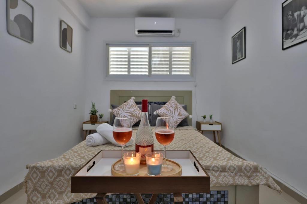 a room with two glasses of wine and candles on a bed at אירוח סמוך לים התיכון יש מקלט בבניין in Haifa