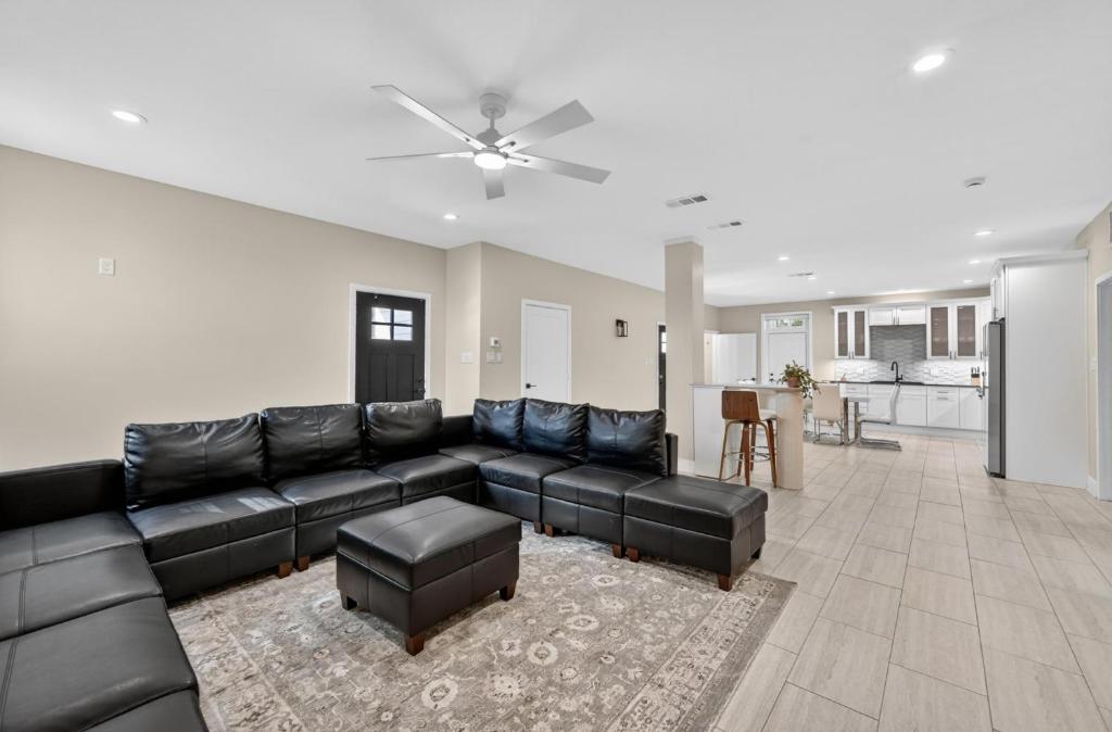 a large living room with a black leather couch at Korovosoto Lodge in Dallas