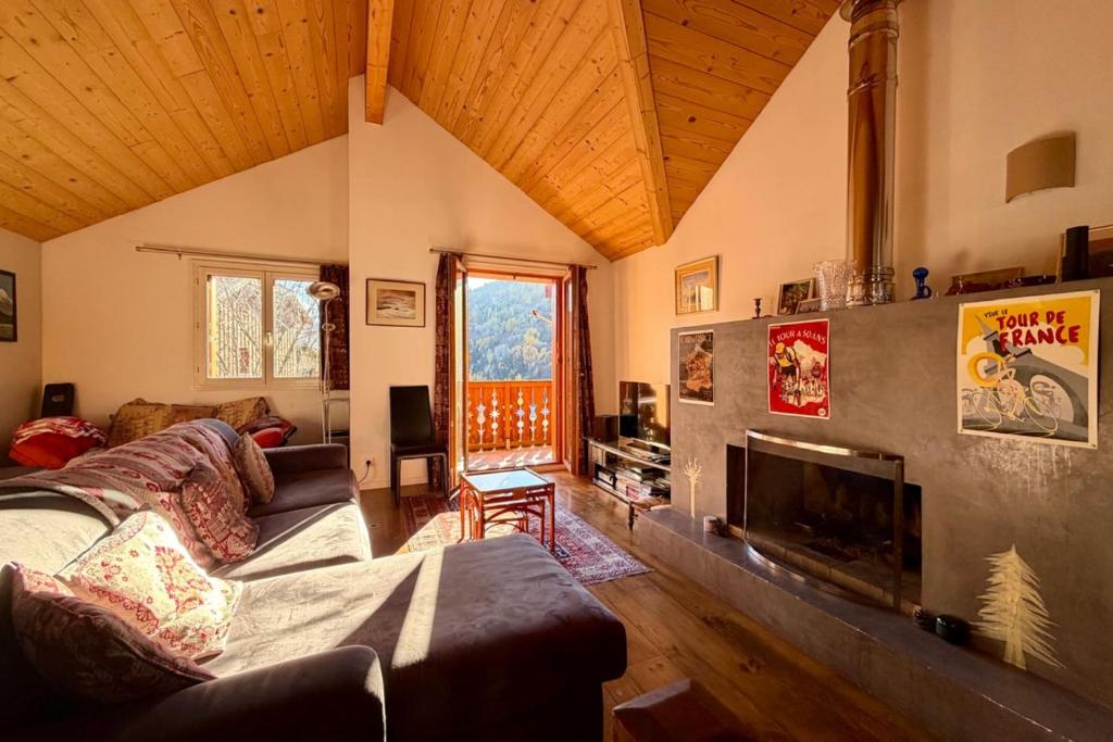 a living room with a couch and a fireplace at Charming and bright cottage in Briançon in Briançon