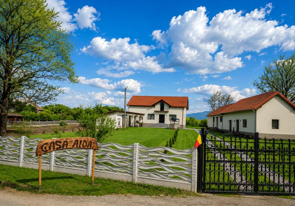 a white fence in front of a house at Casa Aida in Peşteana
