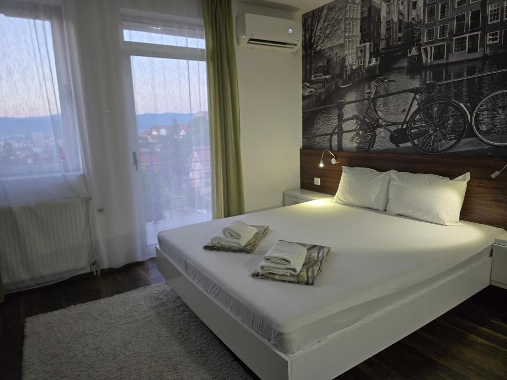 a bedroom with a bed with two towels on it at Sunny apartment in Niš
