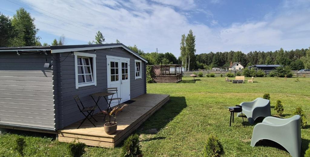 a tiny house on a deck in a field at Kempings Roja in Roja