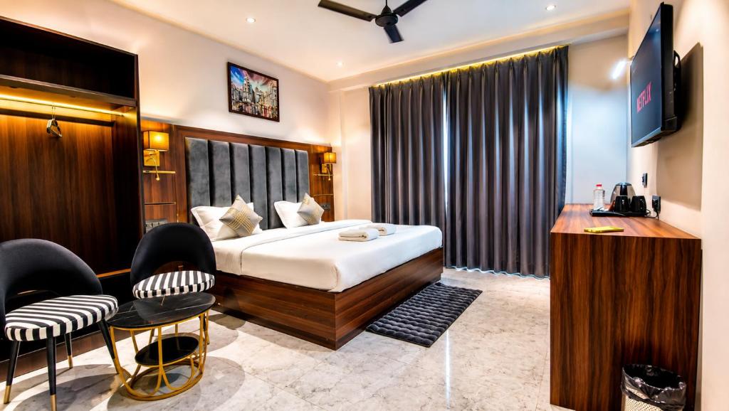 a hotel room with a bed and a television at Hotel Jewels at Rajpur Road in Dehradun