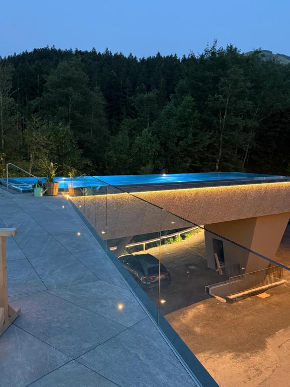 a building with a blue roof with a parking lot at Geniesserhotel Minglers Sportalm 4 Sterne Superior in Kirchberg in Tirol