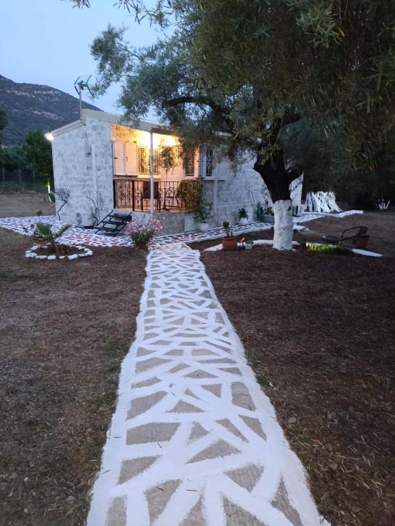 a walkway in front of a house with a tree at Helios Beach House in Mikros Gialos