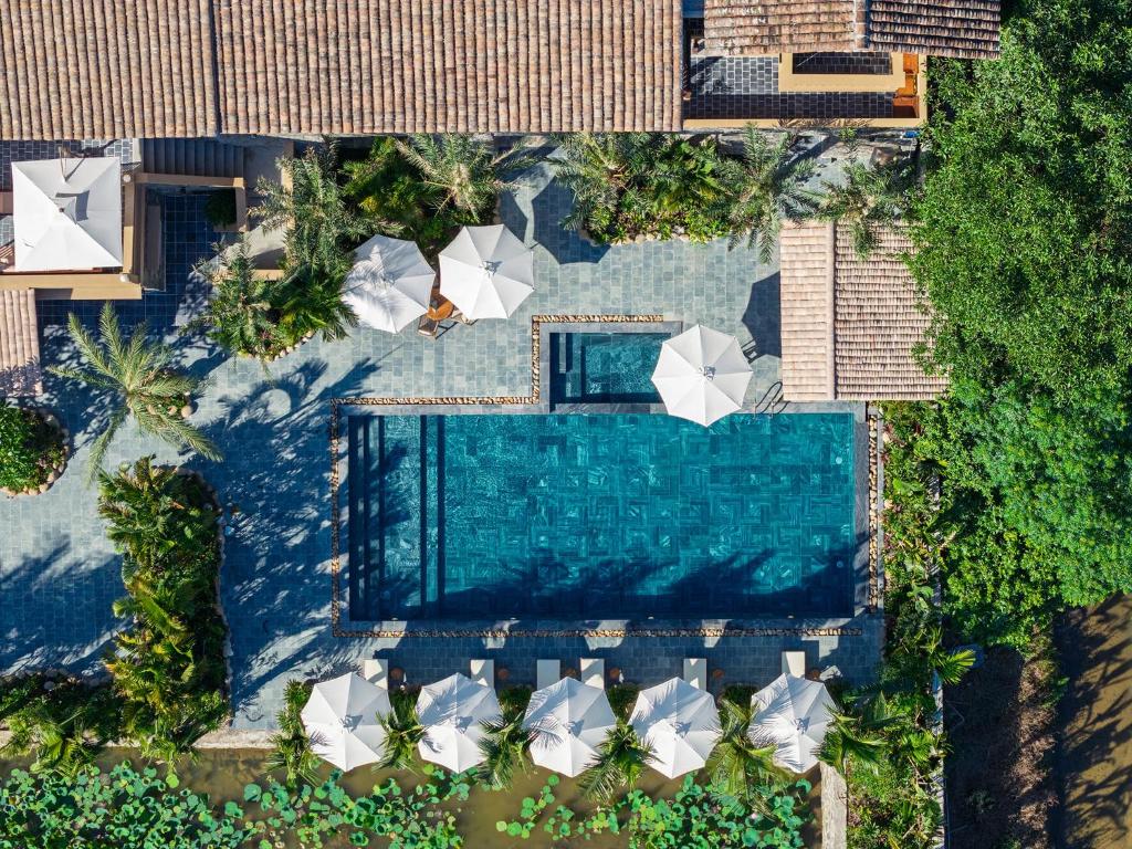 an overhead view of a swimming pool with umbrellas at Hang Múa Ecolodge Ninh Hoà in Ninh Binh