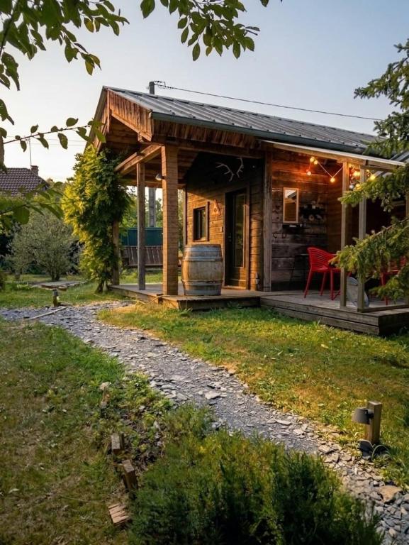 a log cabin with a red chair in a yard at Le Chalet Lasseube in Lasseube