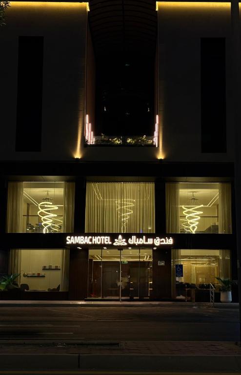 a building with a sign that reads surprise hotel and other shops at Sambac hotel in Jeddah