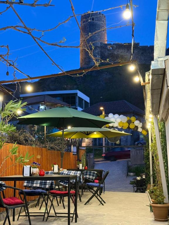a patio with tables and umbrellas at night at Imperia in Akhaltsikhe